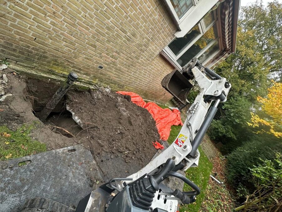 Graafwerk in de tuin voor het vervangen van de riolering